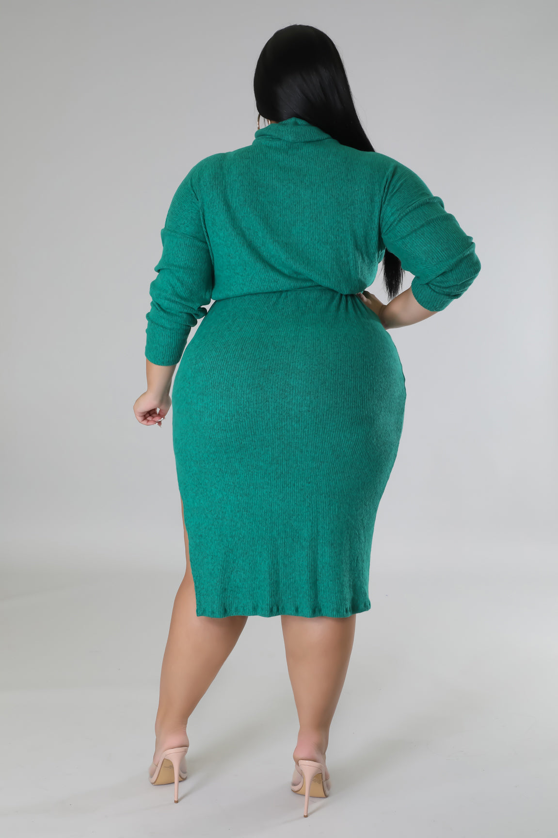 Rear view of model wearing cozy knit turtle neck dress with slit