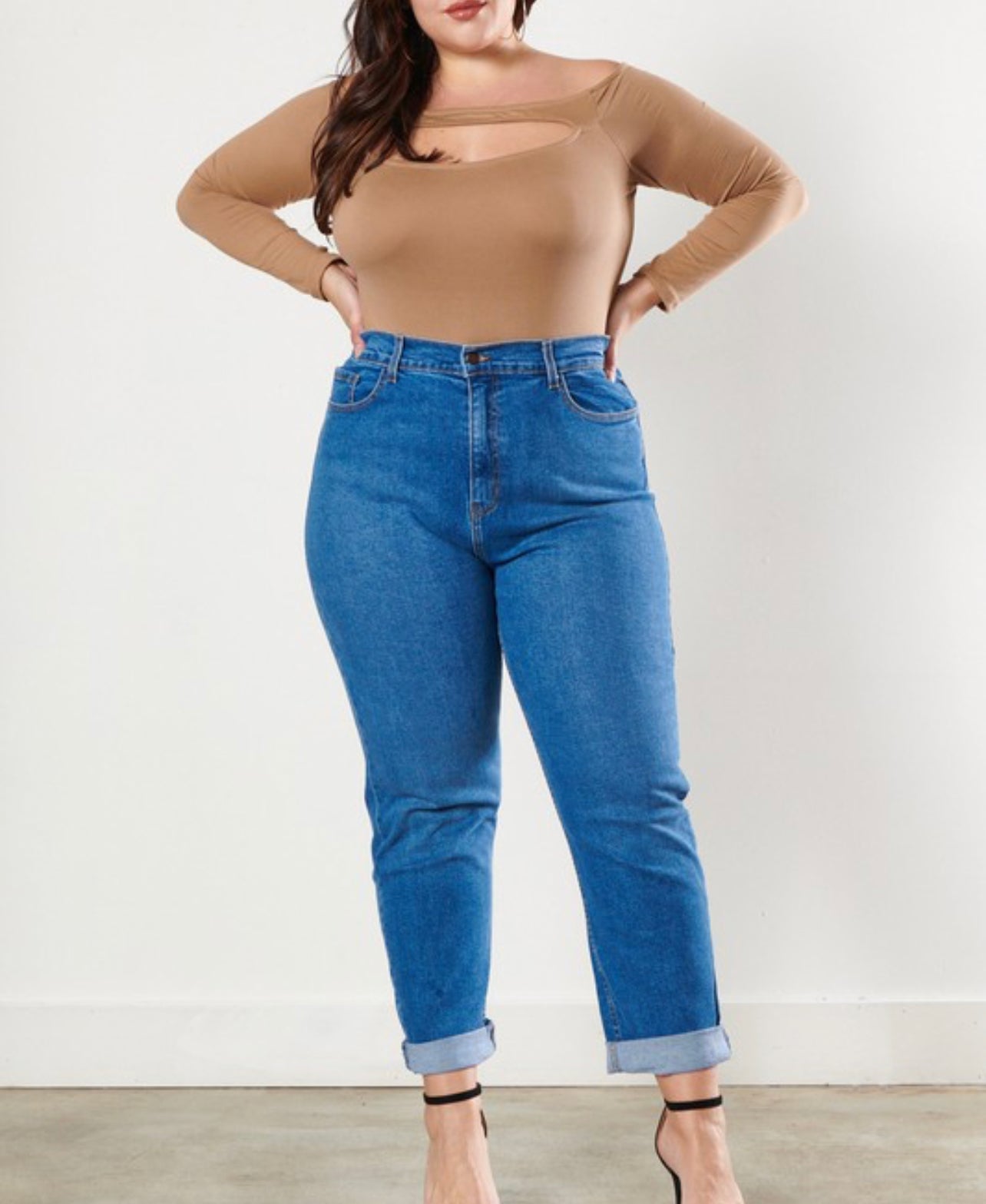 Curvy model wearing Classic High waisted angle jeans while  facing the camera to capture the lips down