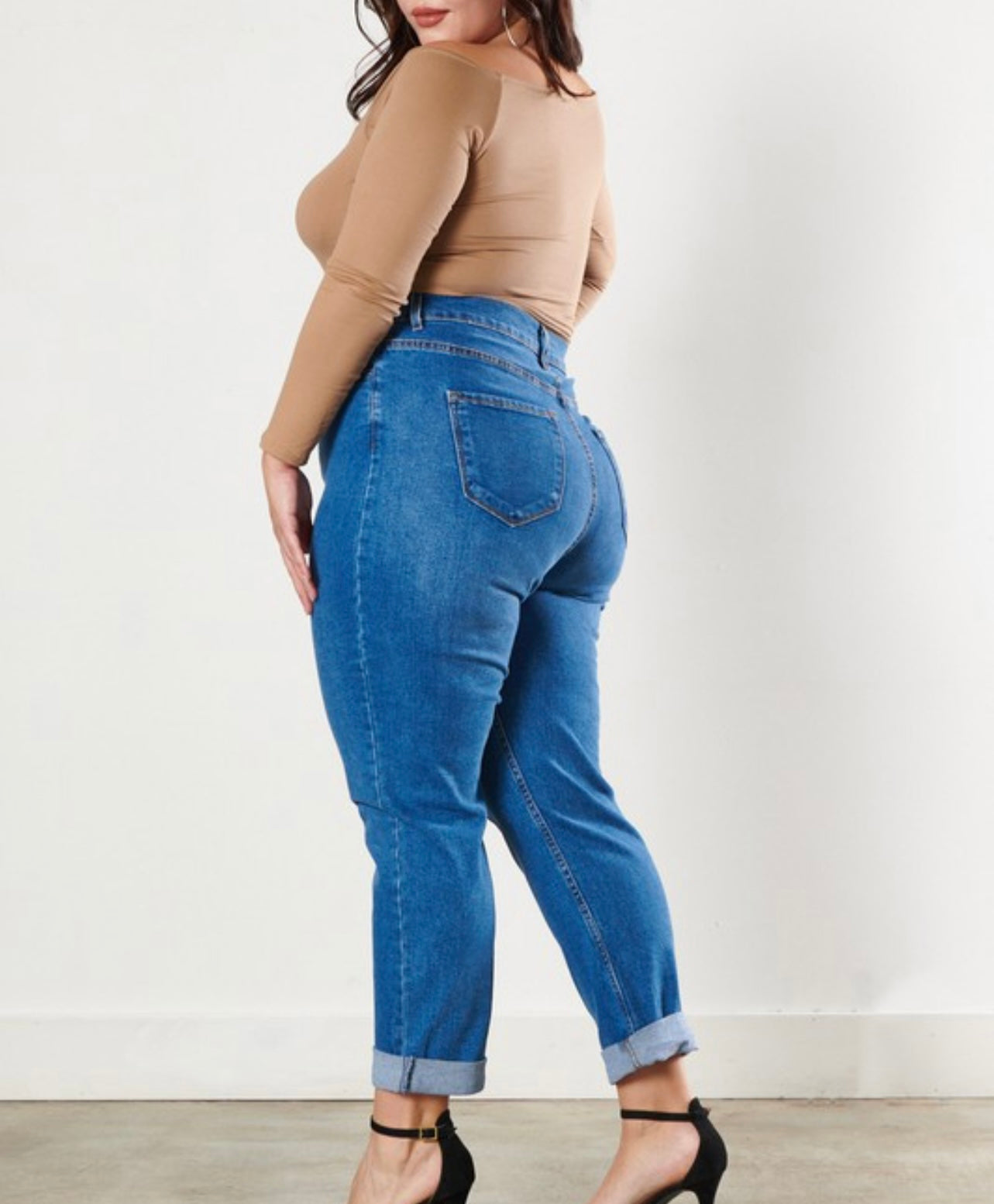 Curvy model wearing Classic High waisted angle jeans while looking over left shoulder
